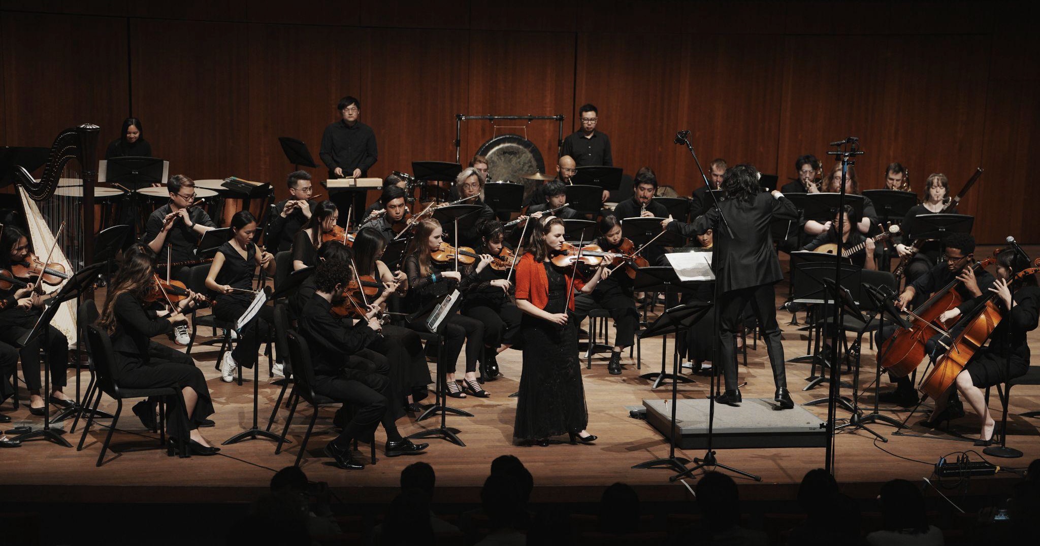 GG Orchestra performing with full orchestra and conductor